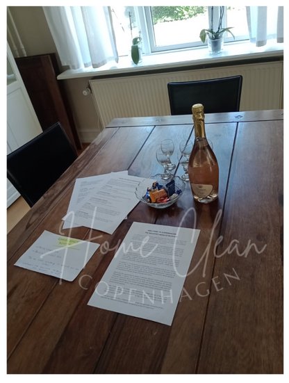 Welcome setup with champagne and documents on a clean Airbnb dining table in Copenhagen, by Home Clean Cph.