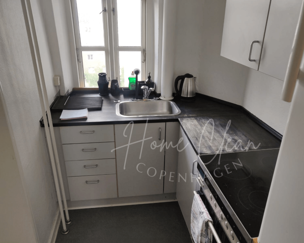 Modern kitchen after a professional deep cleaning service by Home Clean CPH in Copenhagen, showcasing a spotless countertop, sink, and stove